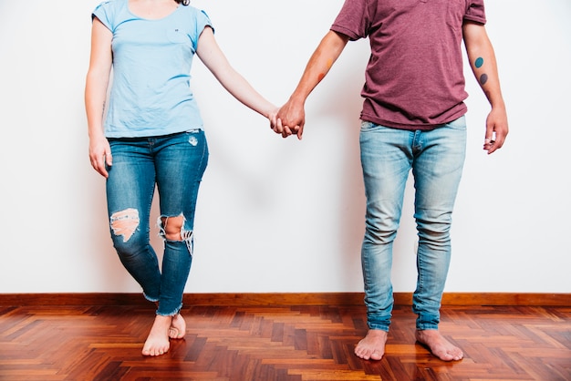 Young barefooted man holding hands with woman