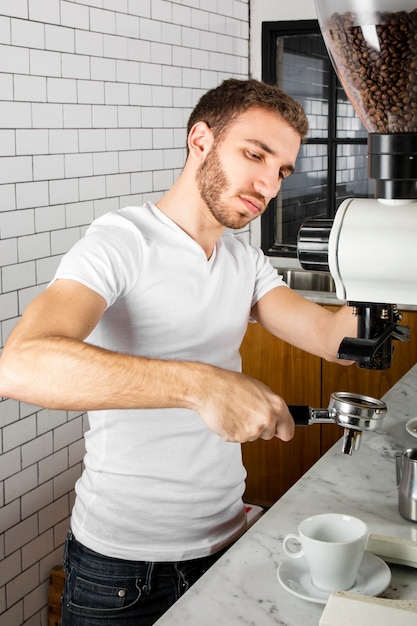 無料写真 一杯のコーヒーを作る若いバリスタ