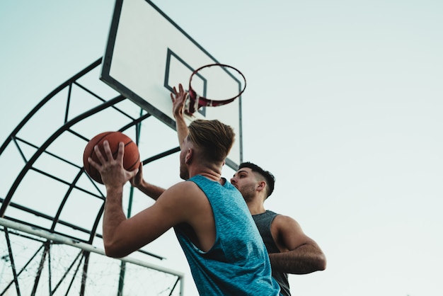 Giovani giocatori di basket che giocano uno contro uno.