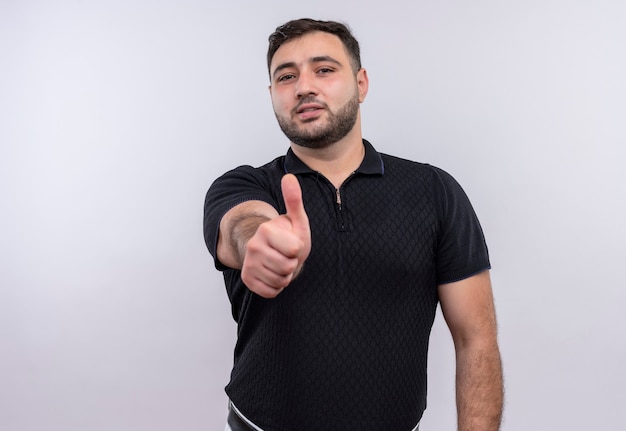 Young bearded man in black shirt happy and positive showing thumbs up 