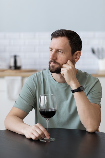 Young bearded man drinking wine
