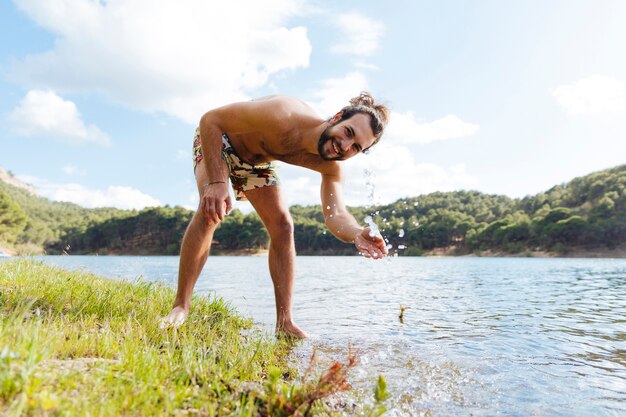 Young bearded man fooling around on lake