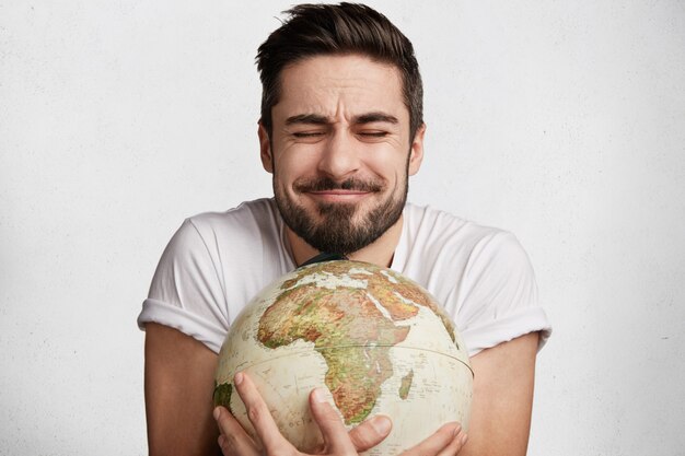 Young bearded man with globe