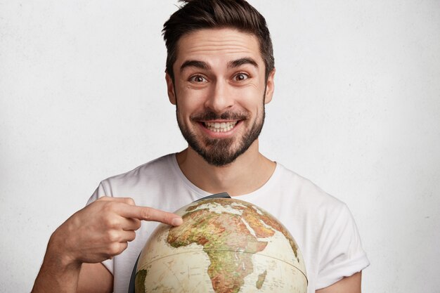 Young bearded man with globe