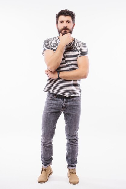 Young bearded Man with his arms crossed over grey wall