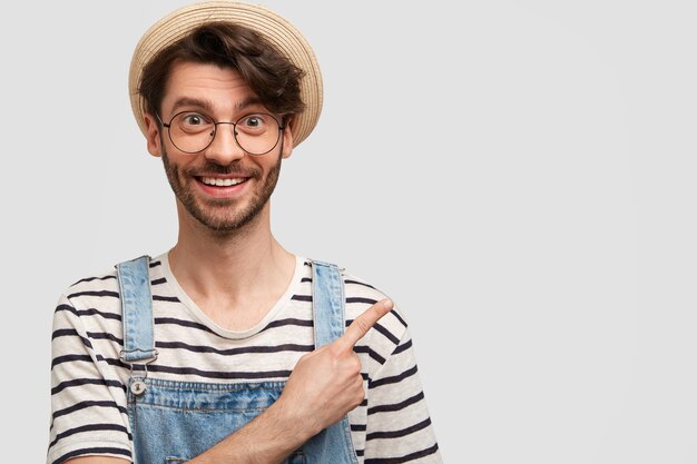 Young bearded man with round glasses and denim overalls