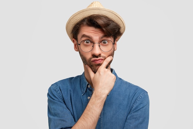 Young bearded man with round glasses and denim shirt