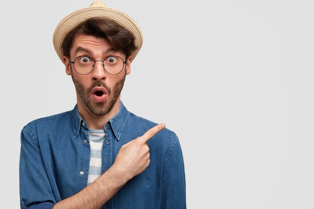 Young bearded man with round glasses and denim shirt