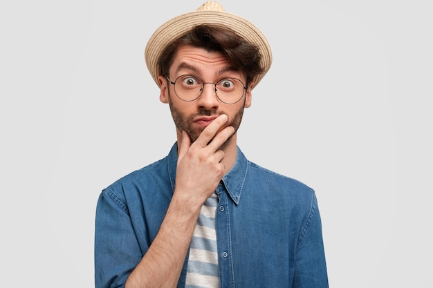 Young bearded man with round glasses and denim shirt