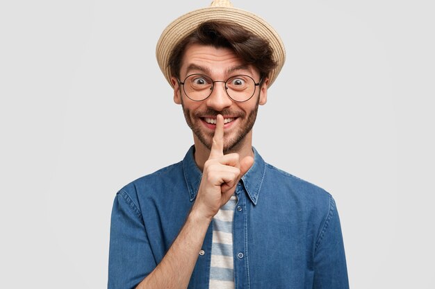 Young bearded man with round glasses and denim shirt