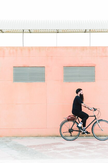 街で自転車に乗ってショルダーバッグを持つ若者を生やした