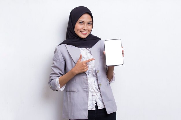 Young beautiful asian muslim woman demonstrating mobile cell phone isolated on white background