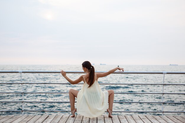 Young beautiful ballerina dancing and posing outside