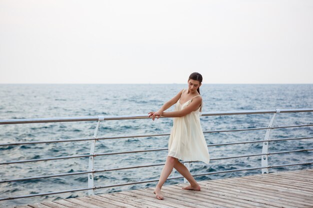 Young beautiful ballerina dancing and posing outside