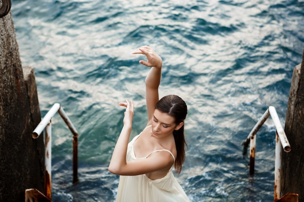 Young beautiful ballerina dancing and posing outside