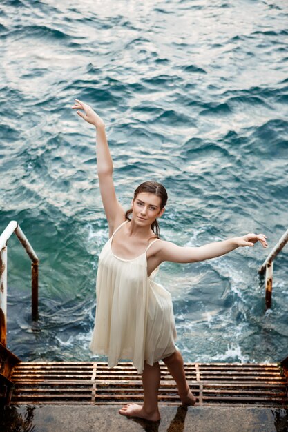 Young beautiful ballerina dancing and posing outside