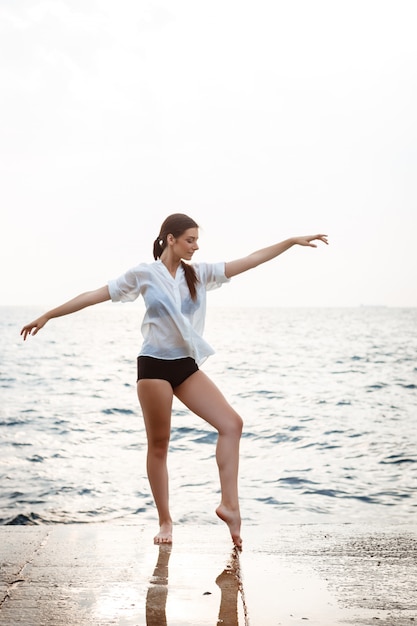 Young beautiful ballerina dancing and posing outside