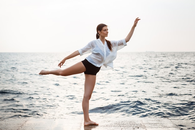 Young beautiful ballerina dancing and posing outside