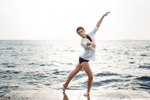 Young beautiful ballerina dancing and posing outside