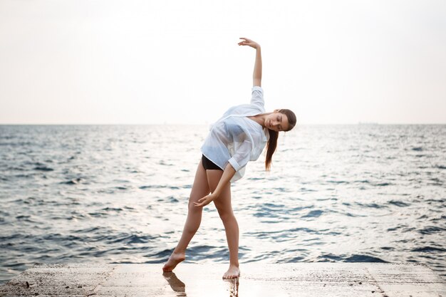 Young beautiful ballerina dancing and posing outside