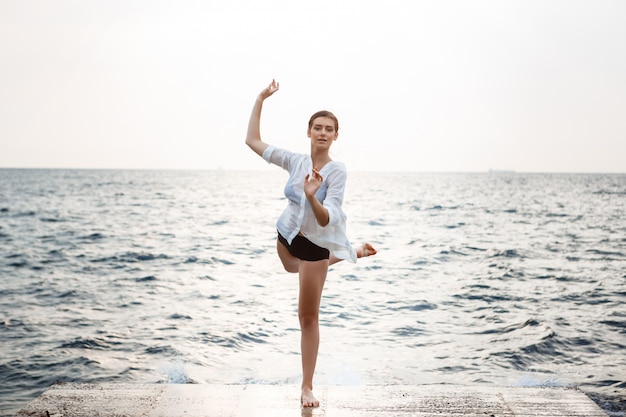 Young beautiful ballerina dancing and posing outside