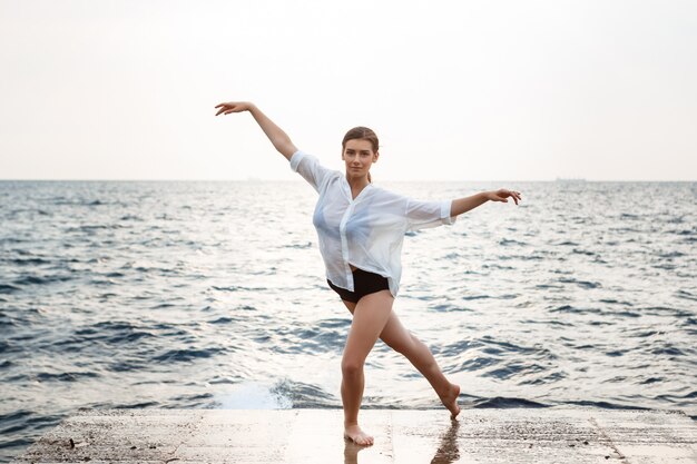 Young beautiful ballerina dancing and posing outside