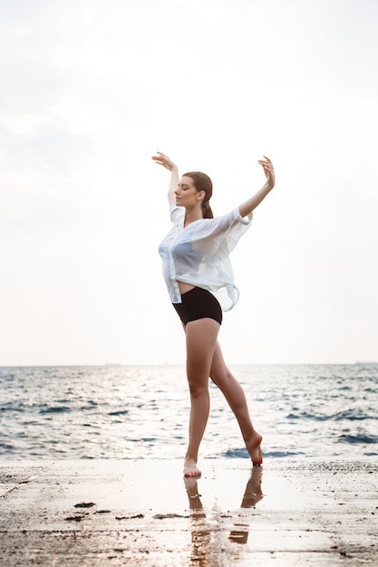 Young beautiful ballerina dancing and posing outside