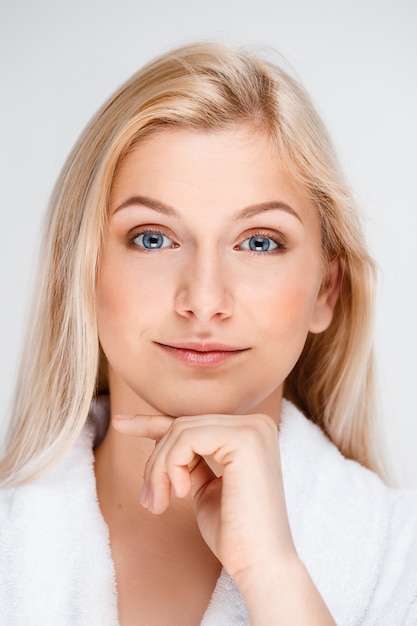 Young beautiful blond woman in bathrobe smiling