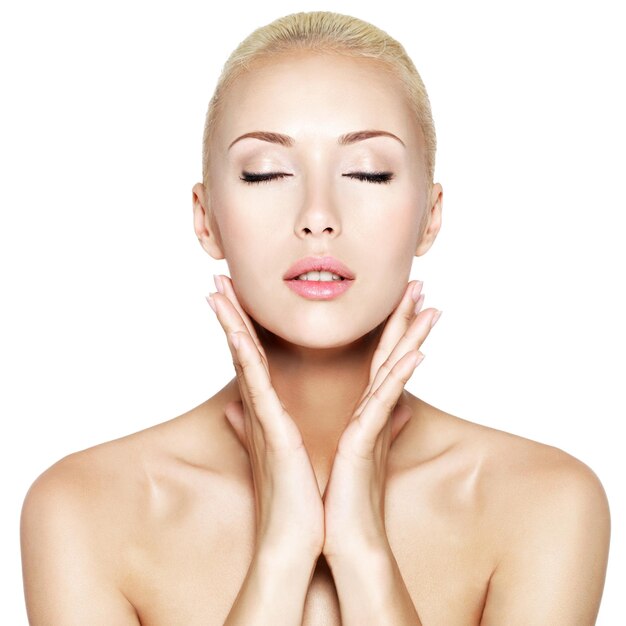 Young beautiful blond woman with closed eyes and hands at health face 