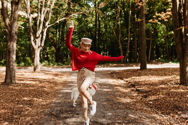 楽しい秋の公園で踊る若い美しいブロンド。