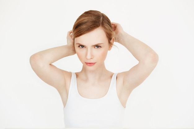 Young beautiful blonde girl with clean fresh skin sitting at table  correcting hairstyle. Beauty and spa.