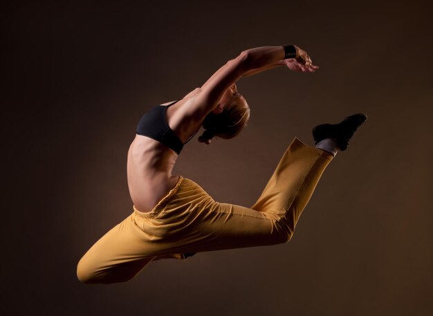 Young beautiful blonde woman jumping in the splits