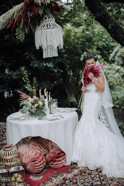 Young beautiful bride holding bouquet in boho style