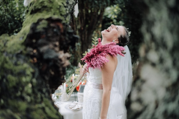 Free photo young beautiful bride holding bouquet in boho style