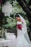 無料写真 自由奔放に生きるスタイルでブーケを保持している若い美しい花嫁
