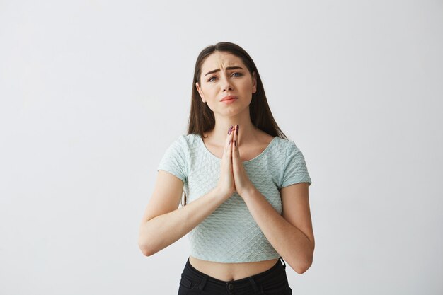 Young beautiful brunette girl praying hoping .