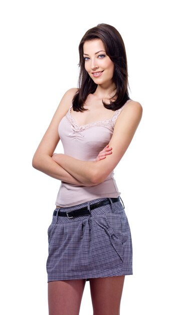 Young beautiful brunette woman standing with crossed arms isolated on white