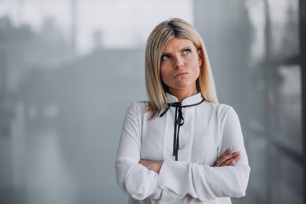 Young beautiful business woman on gray background