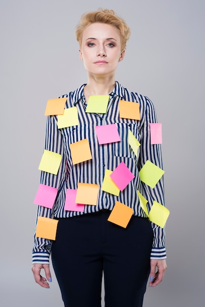 Free photo young beautiful businesswoman with post it notes all over her isolated