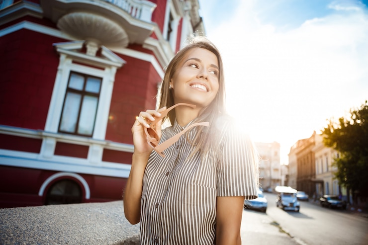 Free Photo young beautiful cheerful woman in sunglasses walking around city, smiling.