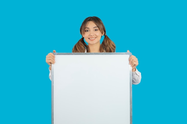 Young beautiful college girl holding White idea board. High quality photo