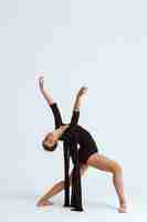 Бесплатное фото Молодой красивый современный танцор представляя над белой стеной. копировать пространство