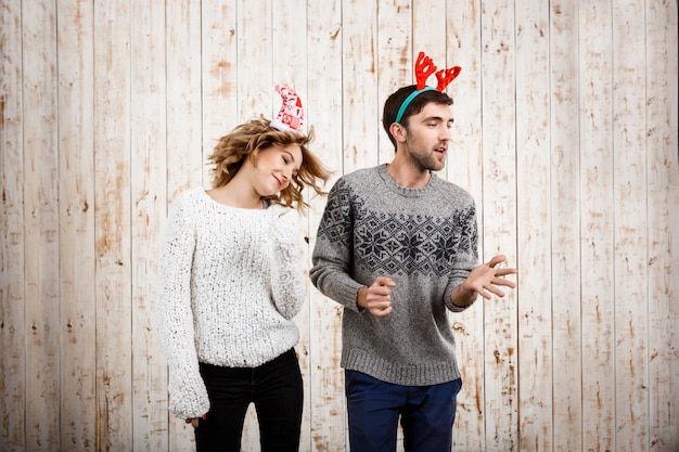 Young beautiful couple dancing have fun over wooden wall