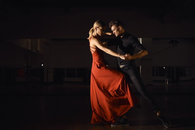 Молодая красивая пара танцует со страстью