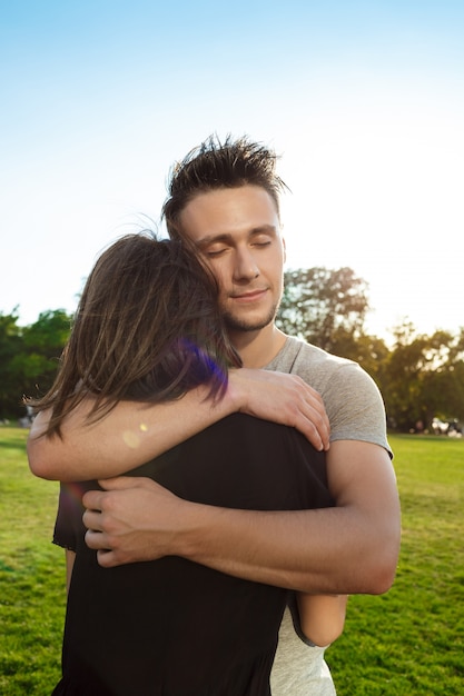 Free photo young beautiful couple embracing in park.