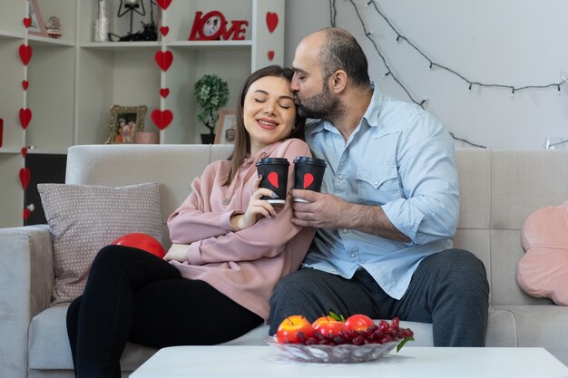若い美しいカップル幸せな男と愛の幸せなコーヒーカップを持つ女性