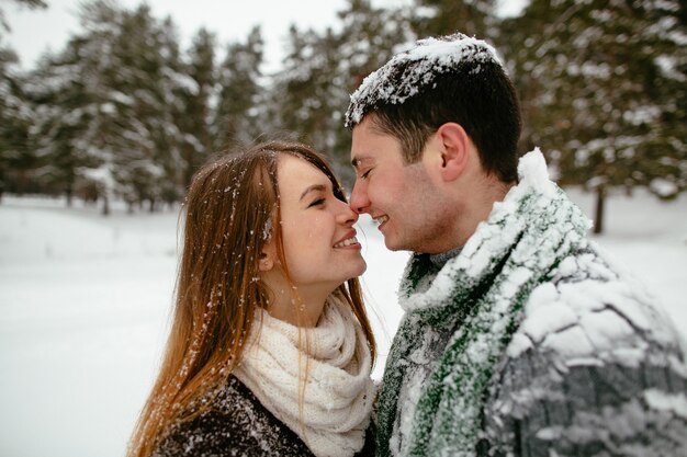 Young beautiful couple having fun and enjoying the snowy weather.