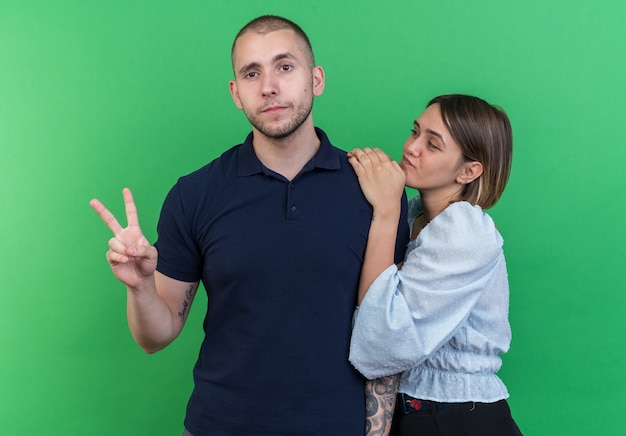 Free photo young beautiful couple man and woman happy and positive showing v-sign smiling cheerfully standing