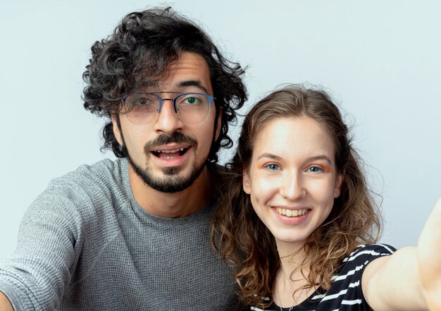 young beautiful couple man and women happy in love smiling cheerfully  over white wall