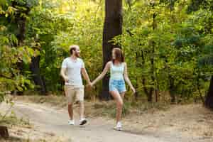 Free photo young beautiful couple resting, walking in park, smiling, rejoicing.